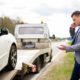 Man calling while tow truck picking up his broken car